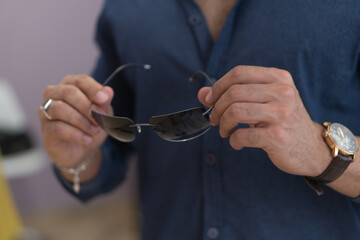 Male strong hand holding elite sunglasses