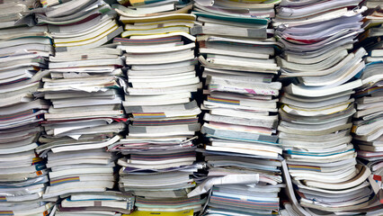 Piles of waste paper waiting to be recycled.pile of textbooks collected at school at the end of the...