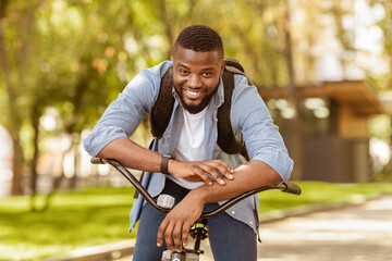 Obraz premium Portrait Of Happy African American Man Sitting On Bicycle And Posing To Camera, Riding Bike Outdoors