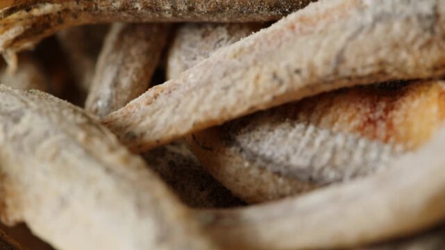 Dry salty fish anchovies on a plate close-up macro. Dried fish snack for beer party at the cafe or bar. Salt and fry snacks food 