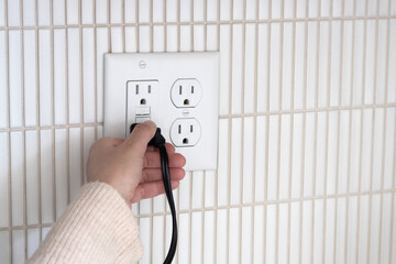 Unplugging a toaster. Unplugging appliance from GFCI electrical outlet. 