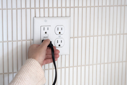 Unplugging a toaster. Unplugging appliance from GFCI electrical outlet. 