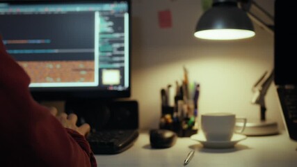 Workplace. Talented guy using intelligence concentratedly writes code pressing buttons in home office. In slow motion skilled specialist looks at pc monitor applies new coding methods, programmer