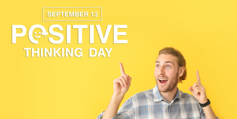 Portrait of happy man pointing at something on color background