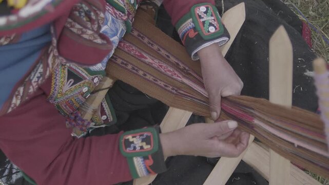 A woman weaves a cloth made from alpaca wool in the Andes of Cuzco, 4,200 meters above the sea. Peru.