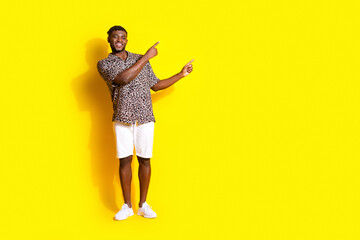Photo of nice cheerful glad man wear trendy clothes presenting empty space isolated on vivid yellow color background