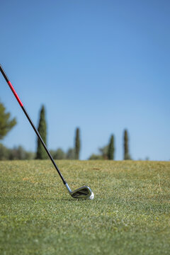Golf club and ball on course under clear sky