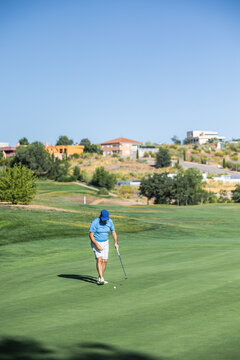 Unrecognizable middle-aged male golfer on course