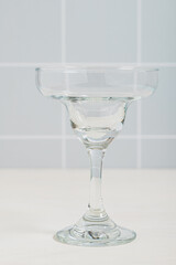 empty margarita cocktail glass. Checkered wall tile background