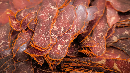 Dried meat slices, showcasing their intricate patterns and textures. The natural colors of dark brown to red blend seamlessly with orange veins