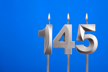 Birthday number 145 - Candle lit on blue background