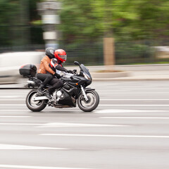 motorcyclist with a passenger rushes down the street on a motorcycle