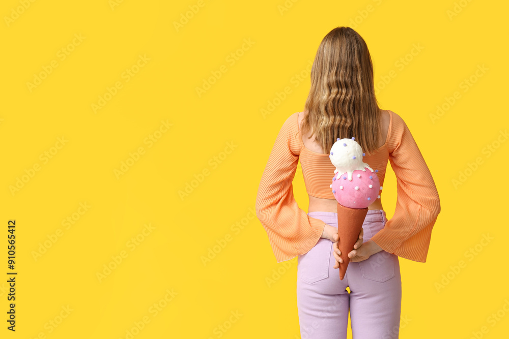 Poster Young woman holding toy ice cream on yellow background