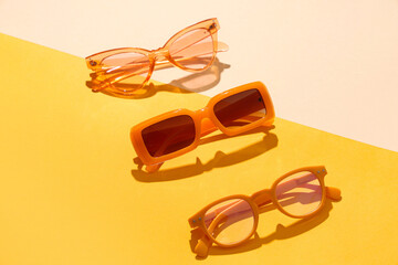 Composition with different sunglasses on color background
