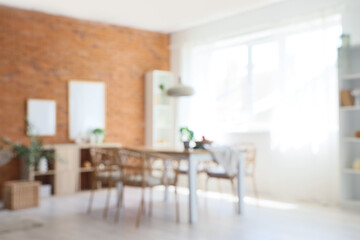 Interior of modern dining room with table and chairs, blurred view