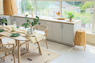 Beautiful setting with green branches on dining table in kitchen