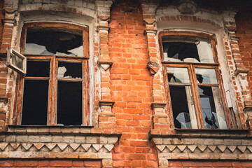 Abandoned Vintage Building With Weathered Windows and Crumbling Brick Facade During Daylight Hours