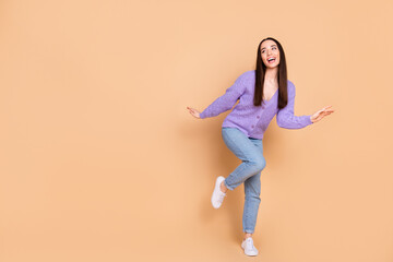 Full size photo of pretty young woman empty space dancing wear cardigan isolated on beige color background