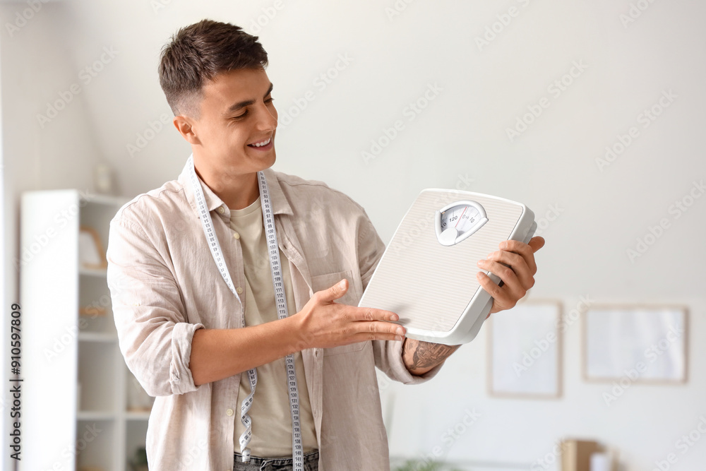 Canvas Prints Young man with weight scales and tape measure at home