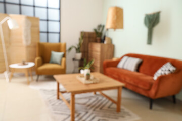 Blurred view of living room with orange sofa and table