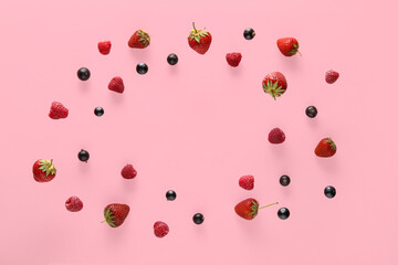 Frame made of different berries flying on pink background