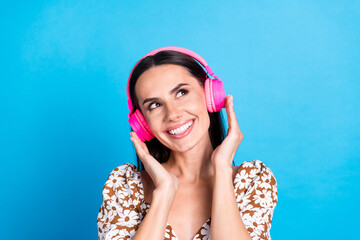 Portrait of nice young lady headphones look empty space wear top isolated on blue color background