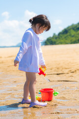 海で砂遊びをする女の子