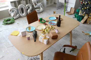Gifts with rubbish on table in messy office after New Year party