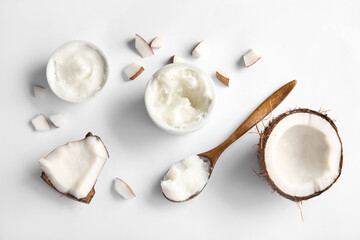 Bowls and wooden spoon of coconut butter on grey background