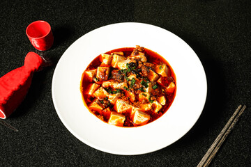 Spicy Mapo Tofu soup with chopsticks served in dish on dark background top view of hong kong food