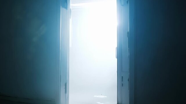 A bright light emanates from a partially opened door in a dark hallway, creating an eerie and captivating atmosphere.