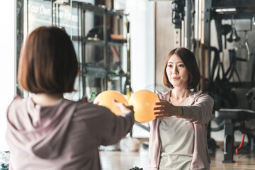 ピラティスボール・ストレッチボールを使ってエクササイズする若いアジア人女性
