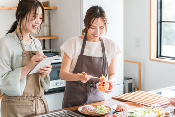 料理教室・クッキングスクールで料理を教える講師の女性と生徒の女性
