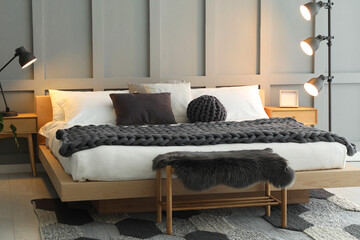Stylish bedroom interior with comfortable bed and lamps