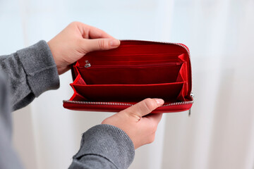Woman with empty wallet indoors, closeup view