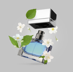 Bottle of floral perfume and jasmine flowers in air on light grey background
