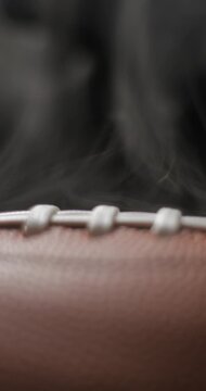 Football ball macro rotating with smoke in studio slow motion, vertical view