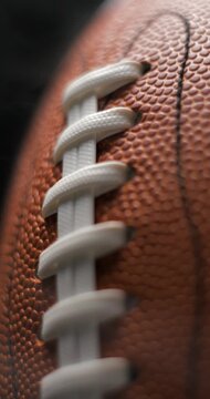 Football ball macro rotating with smoke in studio slow motion, vertical view
