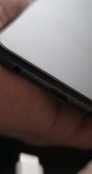 USB-C cable macro plugin to smartphone slow motion, vertical view