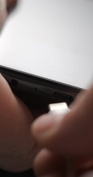 USB-C cable macro plugin to smartphone slow motion, vertical view