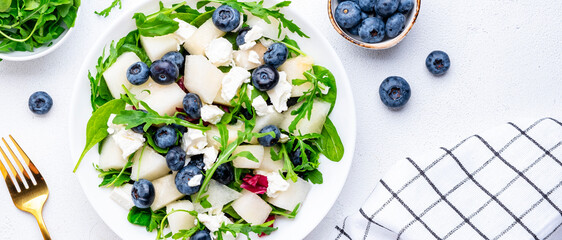 Juicy summer salad with melon, blueberries, ricotta cheese, arugula and spinach., white background,...