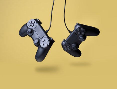 Flying air gamepads from a game console on a yellow background. The concept of games