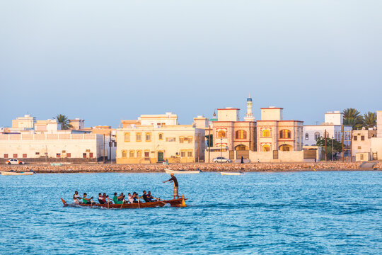 Men on a boat at Al Ayjah harbour at sunset, Sur, Oman
