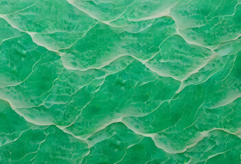 Fototapeta premium An abstract pattern of green waves resembling water surface, with a textured appearance a vibrant green color with a marbled effect, resembling jade. The light creates movement in the design.
