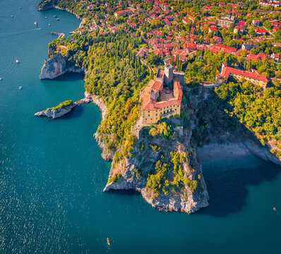 Stright down summer view from flying drone of Duino Castle. Nice morning scene of Adriatic coast of Italy, Europe. Beautiful cityscape of Duino town. Traveling concept background.