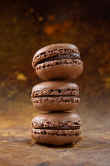 Chocolate macarons on a brown background. Fresh cookies with chocolate. A French sweet delicacy, macarons close up