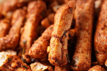 A bowl of Basreng (fried meatballs), a popular Indonesian snack made from thinly sliced fish meatballs, fried until crispy, and coated with spicy seasoning. Photographed against a white background.