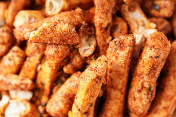 A bowl of Basreng (fried meatballs), a popular Indonesian snack made from thinly sliced fish meatballs, fried until crispy, and coated with spicy seasoning. Photographed against a white background.