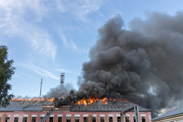 A building is on fire with smoke billowing out of the top