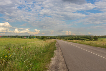 A road with a field of grass in the background